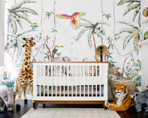 Image shows a mid-century cot with a jungle theme wallpaper and accessories. 